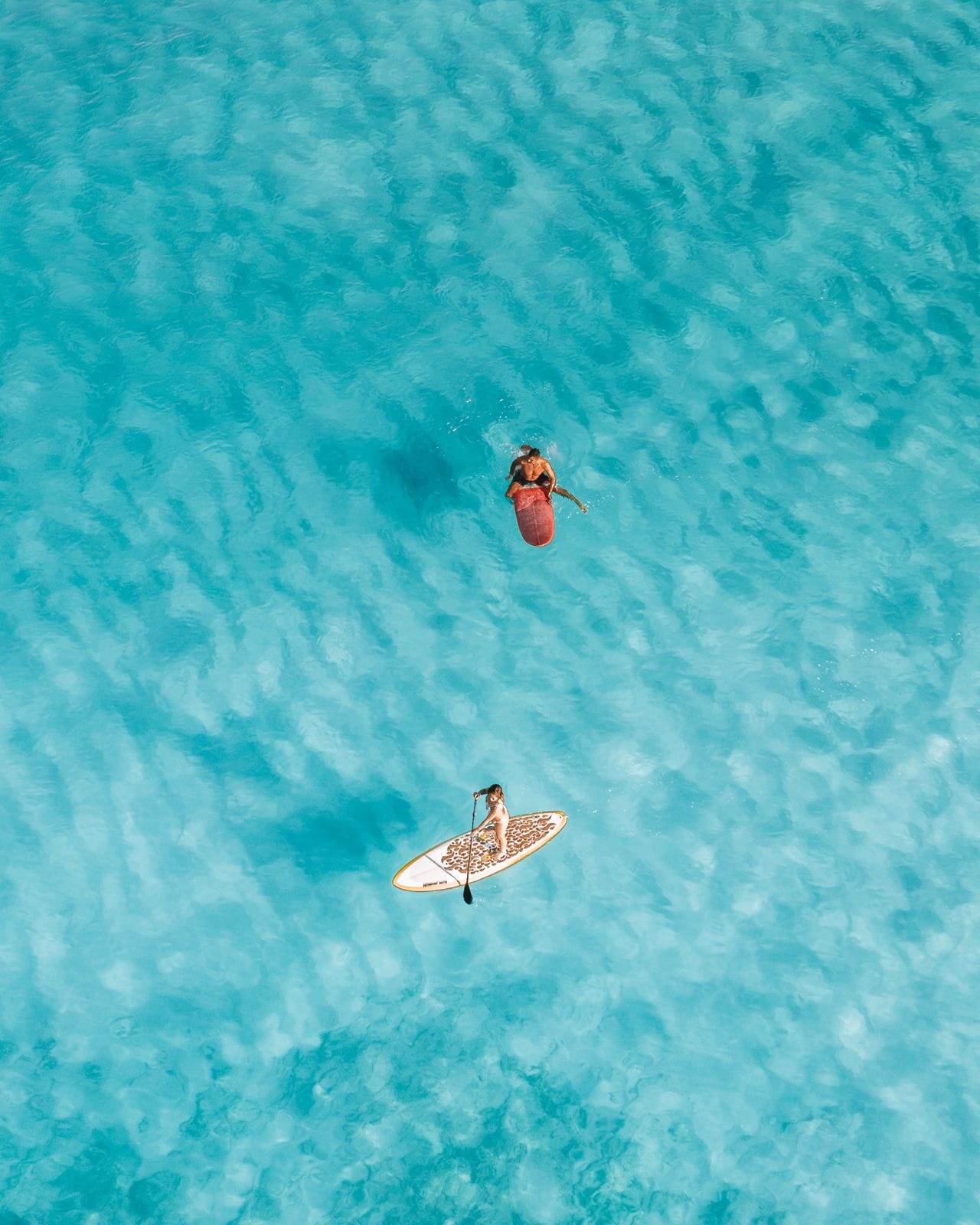 Stand-up paddleboarding on a calm lagoon at sunrise
